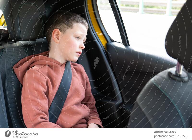 Angeschnallter Junge im Auto schaut weg Sitzgurt PKW Sicherheit Kind Rücksitz sicheres Verkehr Fenster Fahrzeug Sicherheitsgurt Passagier Wegsehen