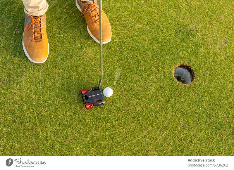 Mit stilvollen braunen Stiefeln auf das Grün setzen Golfer Setzen grün Golfball Golfloch Gras Golfplatz Sport im Freien Spiel Freizeit Putter Club spielen Hobby
