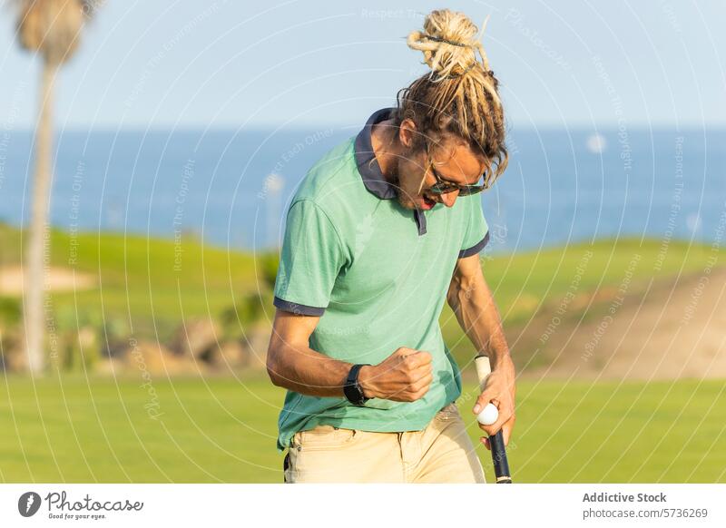 Golfer mit Dreadlocks beim Feiern auf dem Golfplatz Rastalocken männlich sonnig MEER Golfspiel Fröhlichkeit Reaktionen u. Effekte Sport im Freien Freizeit