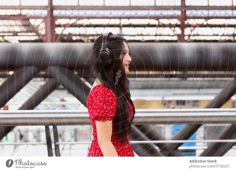 Frau in Rot mit Kopfhörern an einem Bahnhof asiatisch rot Kleid Musik Zug Station jung Erwachsener Freizeit Technik & Technologie Verkehr Eisenbahn Arbeitsweg