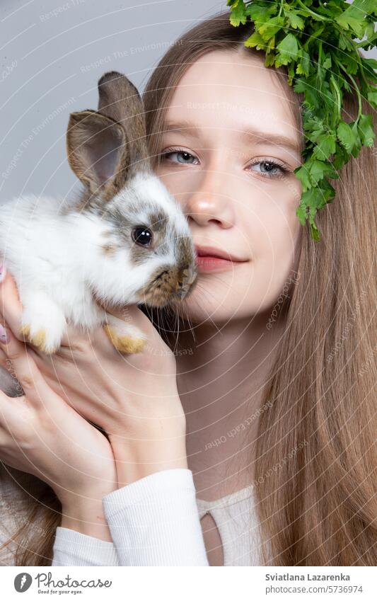 Porträt eines ländlichen Mädchens mit einem Bund Petersilie auf dem Kopf und einem Kaninchen. niedlich Tier Haustiere klein kaukasische Ethnizität Kind