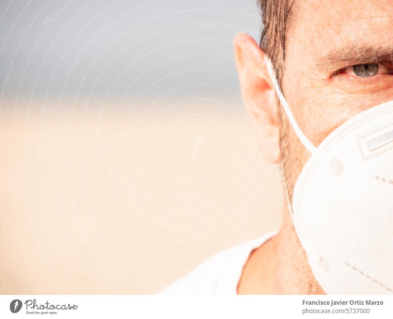 Nahaufnahme des Gesichts eines Mannes mit einer Schutzmaske Auge Person abschließen Coronavirus COVID19 Erwachsener männlich Medizin Strand erwärmen Bakterien