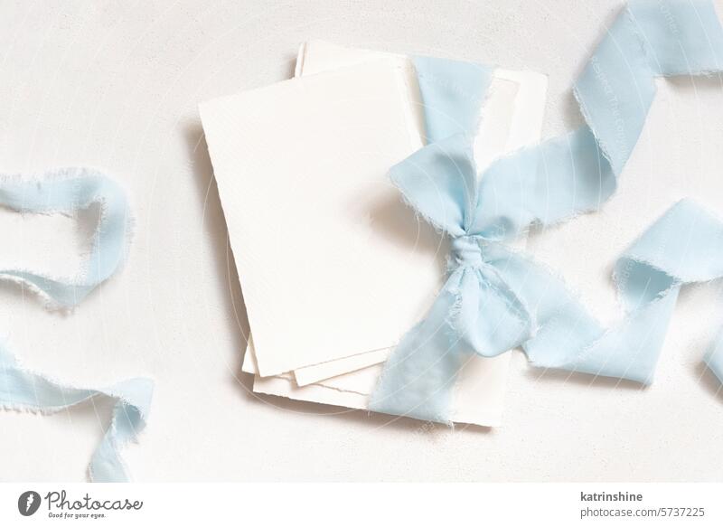 Karten mit einem hellblauen Bänder auf weißem Tisch oben Ansicht gebunden, Kopie Raum, Hochzeit Schreibwaren Mockup Attrappe Postkarte romantisch hell-blau