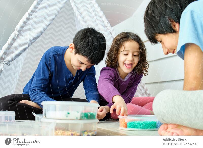 Geschwister haben zu Hause Spaß mit Hama-Perlen Kind spielen Kreativität Junge Mädchen im Innenbereich Freude Konzentration farbenfroh Handwerk Raum gemütlich
