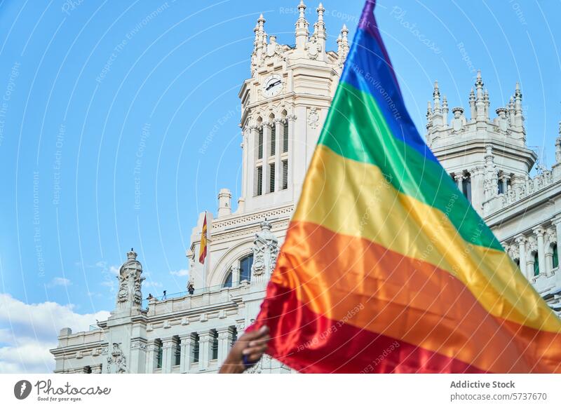 Die Regenbogenflagge weht vor einem klassischen Gebäude Stolz LGBTIQ Vielfalt Gleichstellung Rechte Feier farbenfroh Architektur Himmel blau historisch weiß