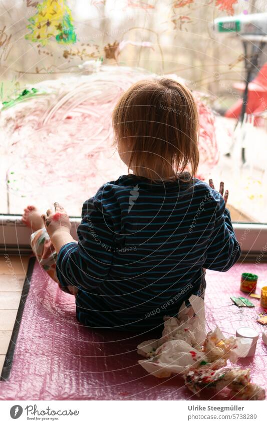 Ein Kind malt mit seinen Füßen an ein Fenster Kinderkunst Leben mit Kindern rot gelb bunt Hand Finger Freude Spaß Fenstermalerei Kreativ mit Kindern