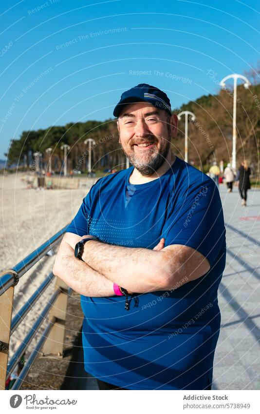 Lächelnder Mann genießt sonnigen Strandtag in Sportkleidung Tag Sportbekleidung Vollbart Glück im Freien Freizeit lässig Erholung MEER Sand Lifestyle