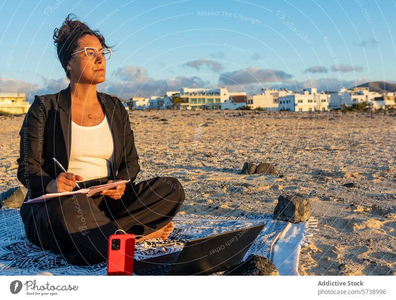 Digitaler Nomade bei der Arbeit am Strand bei Sonnenuntergang Frau digitaler Nomade arbeiten Laptop Smartphone mitschreibend Fernarbeit freiberuflich reisen