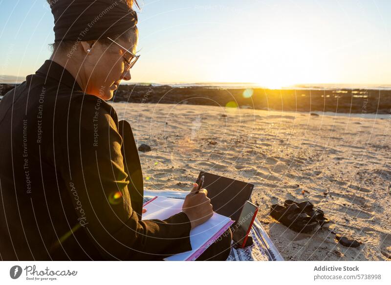 Arbeiten am Strand bei einem atemberaubenden Sonnenuntergang digitaler Nomade mobiles Büro Tablette Sand Frau Technik & Technologie Fernarbeit Freiheit