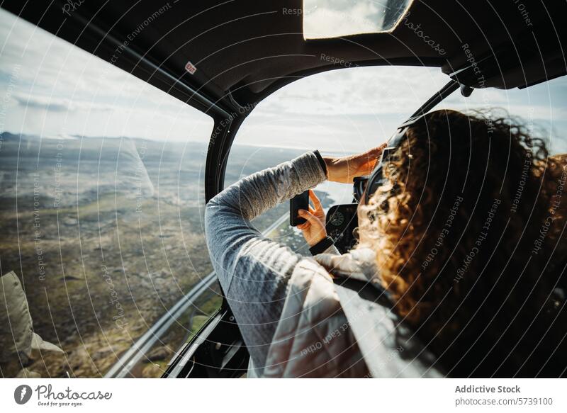 Frau fotografiert mit Smartphone während eines Hubschraubers Sightseeing in Islands wildem Gelände Tour Landschaft robust Antenne Ansicht Abenteuer reisen