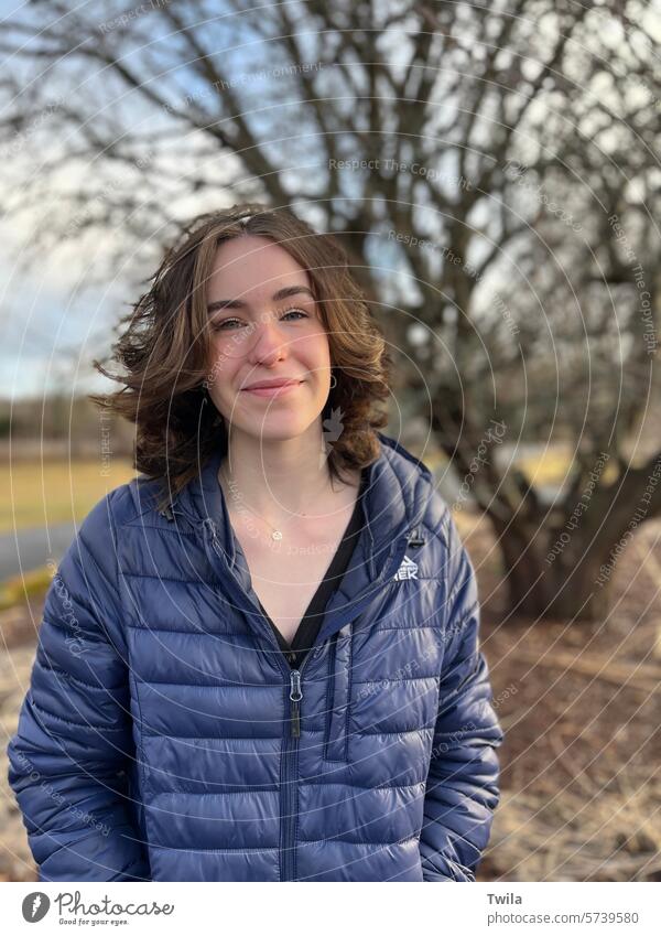 Junge Frau vor einem blattlosen Apfelbaum feminin schön Gesicht Farbfoto 18-30 Jahre Außenaufnahme Porträt