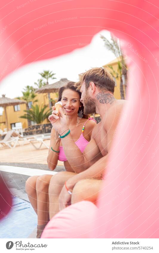 Verspielter Moment am Pool, umrahmt von einem rosa Schwimmkörper Paar spielerisch Schwimmer sonnig Tag Badebekleidung Erholung Urlaub Freizeit Spaß Sommer