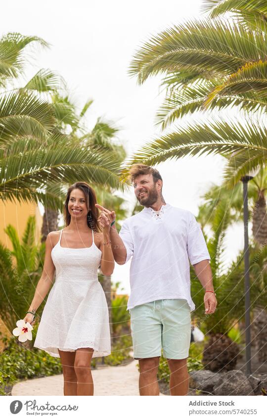 Paar spaziert zusammen in einer tropischen Umgebung Spaziergang Urlaub Handfläche Weg sich[Akk] entspannen Glück Hand in Hand schlendern Mann Frau Sommer