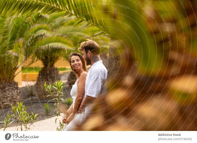 Sommerromantik inmitten von tropischem Grün Paar Outfits Lächeln Händchenhalten Palmen Vegetation Liebe Romantik üppig (Wuchs) Garten Fröhlichkeit Intimität