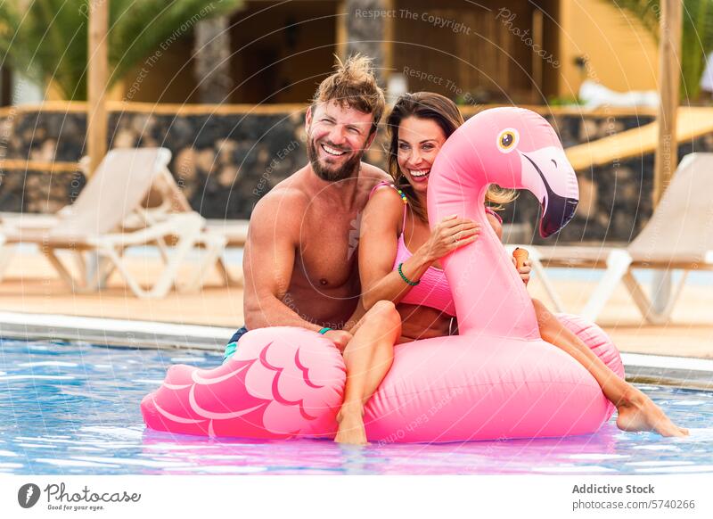 Ein Paar genießt einen Sommertag in einem Pool mit einem Flamingo-Schwimmer Schwimmsport Urlaub Resort Freizeit Spaß Glück Wasser Erholung Lifestyle aufblasbar