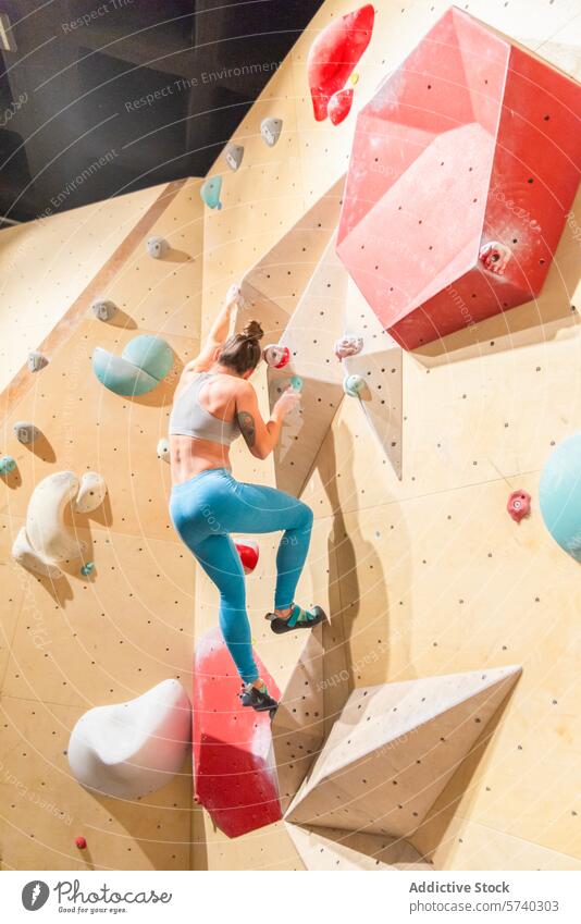 Indoor-Kletterabenteuer mit einer jungen Frau Klettern im Innenbereich Felsen Wand Aktivität Sport Abenteuer Fitness Tatkraft Fokus Übung Griff Halt Stärke