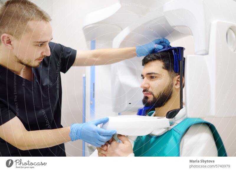 Ein Zahnarzt macht eine digitale Röntgenaufnahme mit einem männlichen Patienten in einer Zahnklinik. Panorama-Röntgenaufnahme. Moderne professionelle zahnärztliche Ausrüstung für Krankenhaus, Klinik, medizinisches Zentrum.