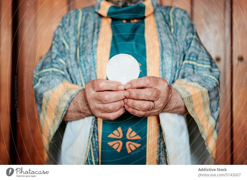 Nahaufnahme der Hände eines anonymen Priesters, der die eucharistische Hostie überreicht, ein heiliges Symbol des christlichen Abendmahls Wirt Eucharistie