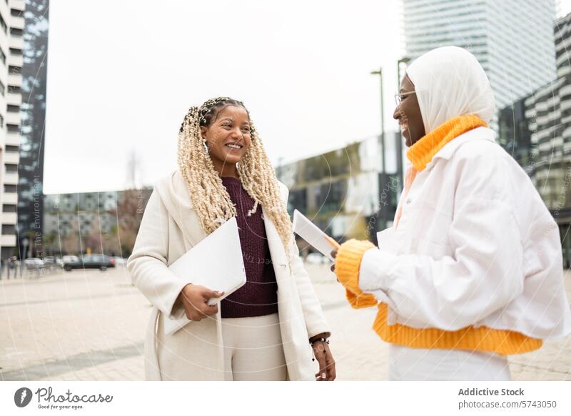 Lächelnde Frauen, die sich im Freien in einer städtischen Umgebung unterhalten Gespräch Großstadt Straße urban freundlich Kameradschaftlichkeit Freundschaft