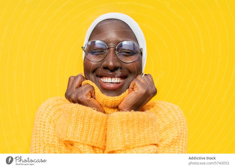 Fröhliche afroamerikanische Frau in leuchtendem Gelb Afroamerikaner Fröhlichkeit freudig heiter pulsierend gelb Pullover Hijab hell Mode Stil Bekleidung Komfort