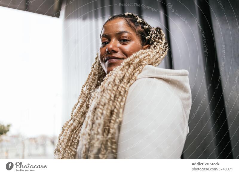 Selbstbewusste afroamerikanische Frau in städtischer Umgebung Afroamerikaner Großstadt urban Lächeln selbstbewusst stylisch Zopf Schal Mode Straße lässig