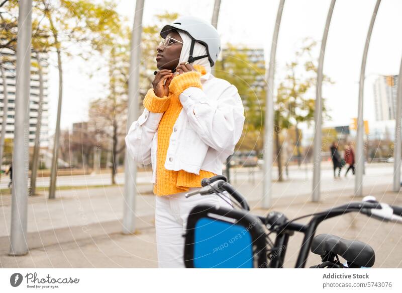 Schwarze Frau passt Helm in der Nähe von Fahrrad in der Stadt an schwarz Großstadt urban elektrisch Schutzhelm Hijab Sicherheit Mode Lifestyle im Freien Park