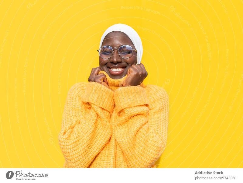 Fröhliche afroamerikanische Frau in leuchtendem Gelb Afroamerikaner Fröhlichkeit freudig heiter pulsierend gelb Pullover Hijab hell Mode Stil Bekleidung Komfort