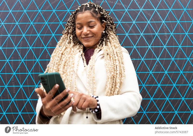 Lächelnde schwarze Frau mit Smartphone in städtischer Umgebung Afroamerikaner Großstadt urban Inhalt geometrische Kulisse Mobile Telefon Gerät Apparatur