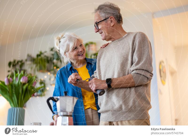 Älteres Ehepaar bei der Kaffeezubereitung zu Hause Menschen Kaukasier graue Haare lässig Tag Porträt im Innenbereich echte Menschen weiße Menschen Erwachsener