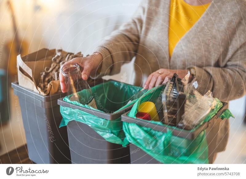 Ältere Frau sortiert zu Hause den Müll in die Recyclingtonne Menschen lässig Tag Porträt im Innenbereich echte Menschen weiße Menschen Erwachsener reif