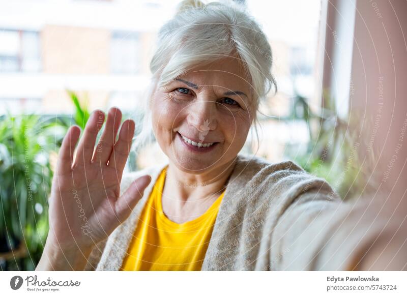 Porträt einer lächelnden älteren Frau, die ein Selfie zu Hause macht Menschen lässig Tag im Innenbereich echte Menschen weiße Menschen Erwachsener reif