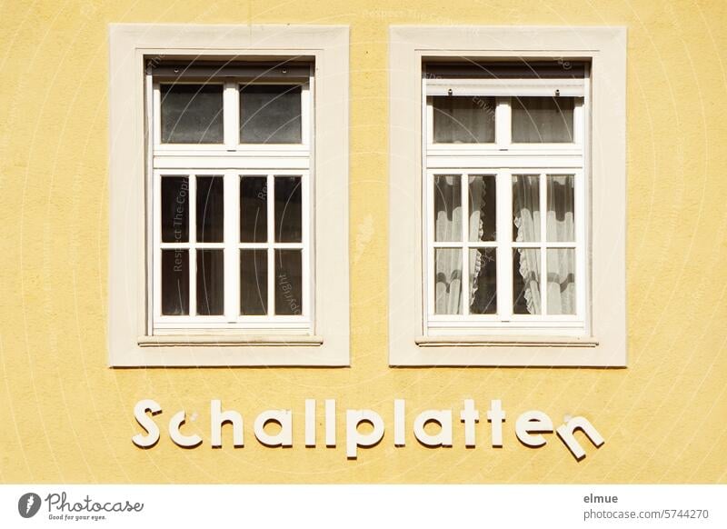gelbe Hausfassade mit zwei Fenstern und maroden Buchstaben - Schallplatten - Nostalgie Plattenladen Vinyl Musik Musikladen Erinnerung Vergangenheit Medien Blog