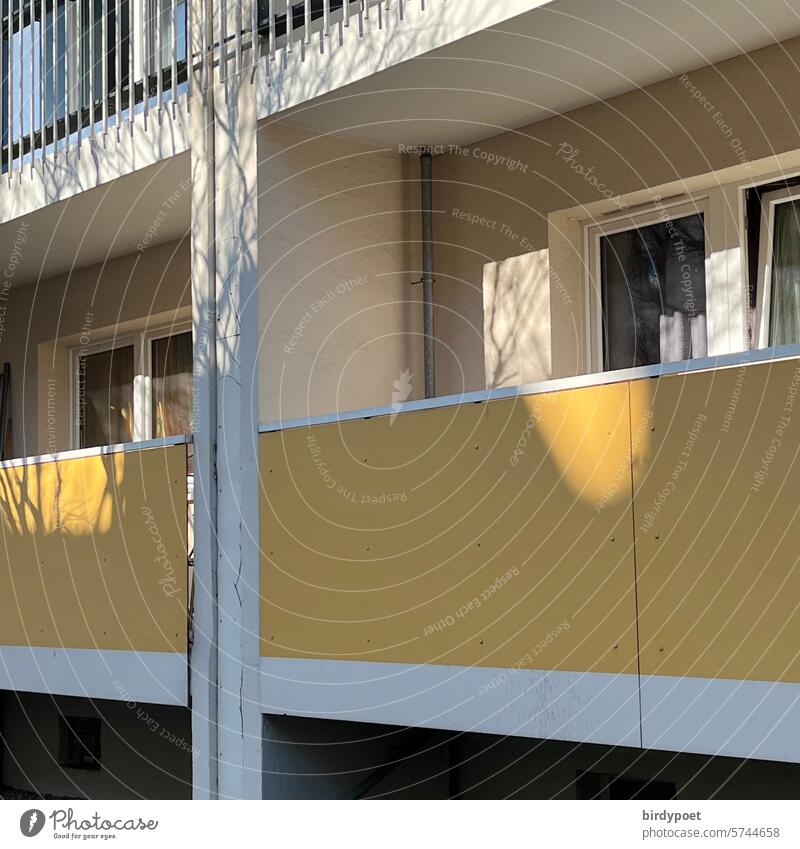 Frühlingssonne auf gelben Balkon malt Baumschatten Sonnenflecken weiss Wand Schatten Bäume Hauswand Häuserwand Ostern Balkonien Fassade Sonnenlicht
