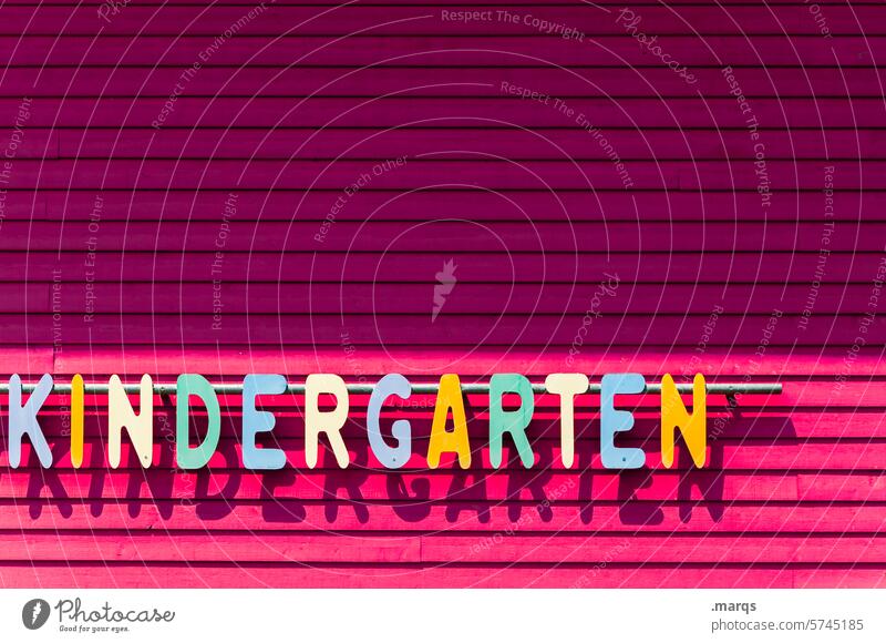 Kindergarten Schriftzeichen Buchstaben Fassade Streifen kinderbetreuung Kindertagesstätte kita Kindheit Kindererziehung mehrfarbig rosa Holzwand Licht Schatten
