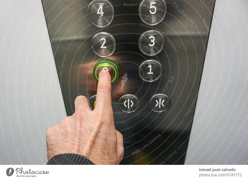 Hand drückt Knopf im Aufzug Körperteil Finger schieben drücken Presse Pressen Schaltfläche Knöpfe Fahrstuhl betätigen Schalter