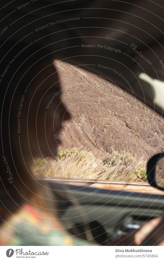 Frau fährt in einem Auto durch die Berge, Nahaufnahme, unscharf mit Fokus auf den Berg. Road Trip und Abenteuer. PKW Fahrer Berge u. Gebirge Autoreise reisen