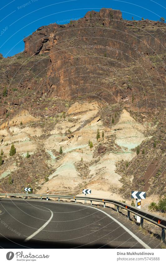 Kurvenreiche Straße in den Bergen mit Blick auf Felsen und Berggipfel bei sonnigem Wetter auf der Insel Gran Canaria Serpentinen Abenteuer Autoreise reisen