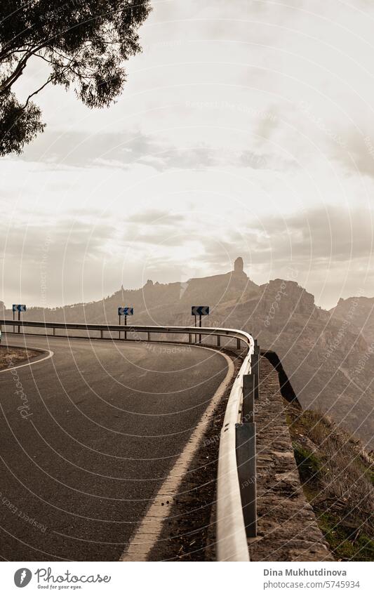 Kurvenreiche Straße in den Bergen mit Blick auf Fels- und Berggipfel bei bewölktem Wetter auf der Insel Gran Canaria Serpentinen Abenteuer Autoreise reisen