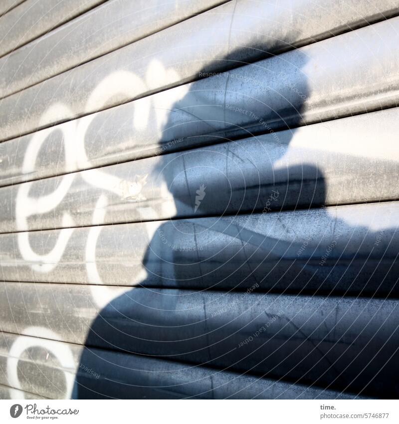 Silhouette auf Jalousie Rolladen sonnig Grafitti glanzen Perspektive Winkel Fassade