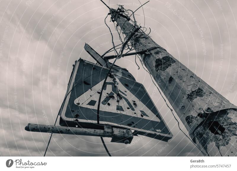 ein von Scherben zerbrochener Betonpfeiler und ein Straßenschild vor einem düsteren Himmel donezk Kherson kyiv Lugansk mariupol Russland Ukraine Saporoschje