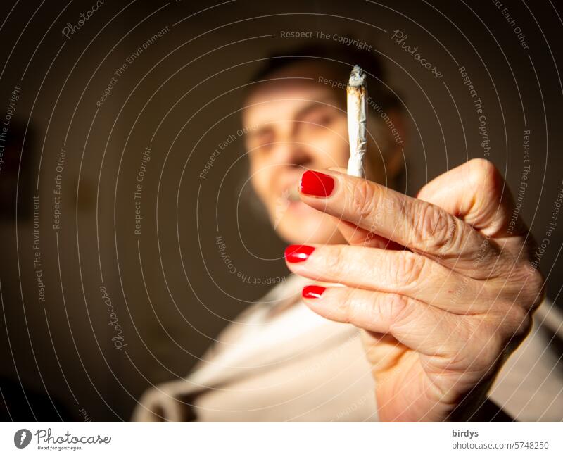 bekiffte, ältere Frau bietet lachend einen Joint an Kiffen anbieten Cannabis rauchen Rausch THC Rauschmittel Freude stoned Stimmungsaufheller berauscht
