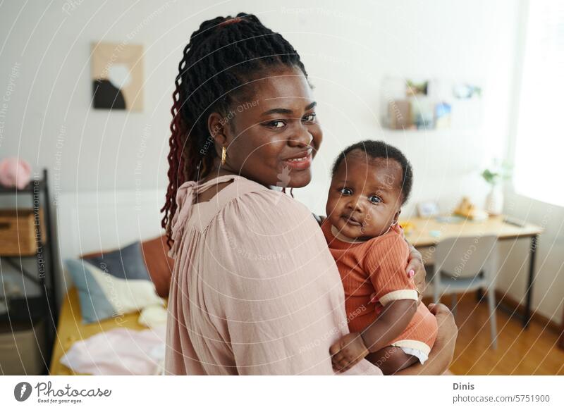 Portrait of Black woman with little baby in hands standing in bedroom Black baby newborn girl infant home childhood small innocent motherhood parenthood