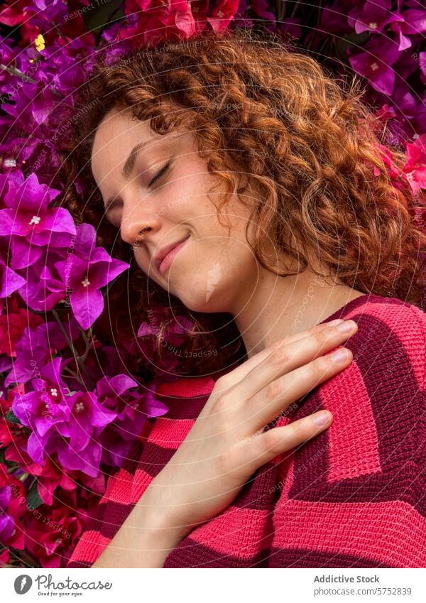 Serene rothaarige Frau mit geschlossenen Augen gegen bunte Blumen krause Haare friedlich Gelassenheit rosa Blumen pulsierend blüht Natur Schönheit Erholung Ruhe