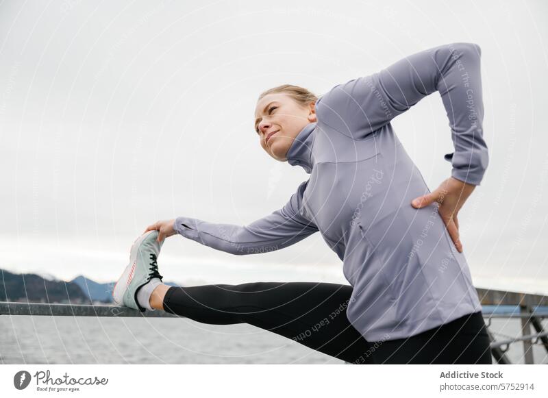 Junge Frau dehnt sich vor dem Training im Freien strecken Übung Fitness Athlet wolkig Tag Wasser Hintergrund Vorbereitung Routine Gesundheit aktiver Lebensstil