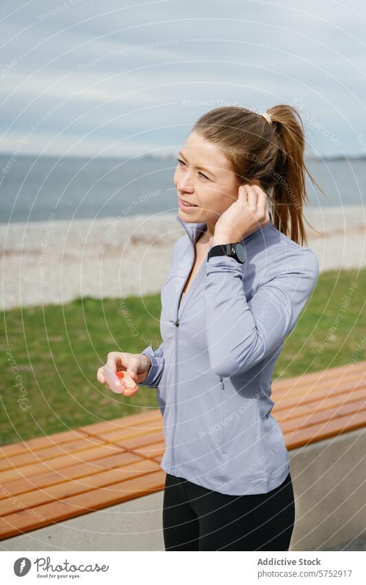 Fitness-Enthusiast bereitet sich auf Seaside Run vor Frau Kopfhörer laufen Seeküste Tracker Handgelenk aktiv Vorbereitung Gesundheit Training Lifestyle Übung