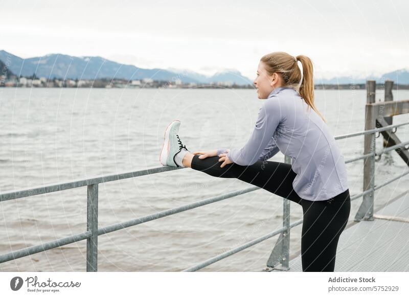 Beinstrecker am Wasser mit Blick auf die Berge Frau strecken Reling Hafengebiet Berge u. Gebirge Hintergrund Fitness Übung im Freien Wellness sportlich