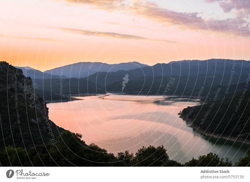 Eine heitere Dämmerungsszene, in der die untergehende Sonne einen rosigen Farbton auf einen ruhigen See inmitten der spanischen Berge wirft Sonnenuntergang