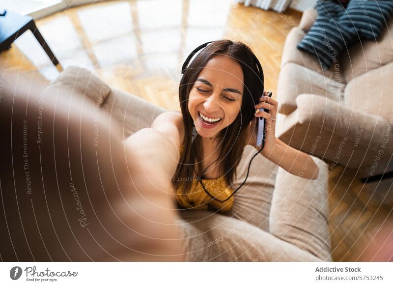Glückliche junge Frau, die ein Selfie mit Kopfhörern macht lateinamerikanerin lateinamerikanisch Latein Lächeln heimwärts heiter Innenbereich Freizeit Lifestyle