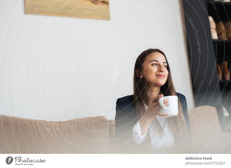 Frau genießt eine friedliche Kaffeepause zu Hause heimwärts Sofa Lächeln Ruhe Komfort Pause schlürfend entspannt Inhalt Getränk Tasse Morgen Freizeit Lifestyle