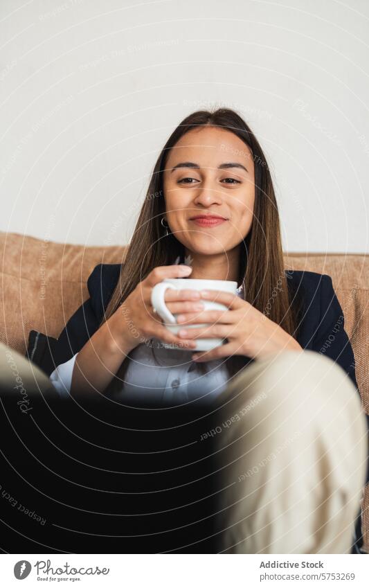 Lächelnde Geschäftsfrau bei einer Kaffeepause Frau Pause Becher Liege Inhalt jung professionell sich[Akk] entspannen Komfort korporativ Büro lässig Mitarbeiter